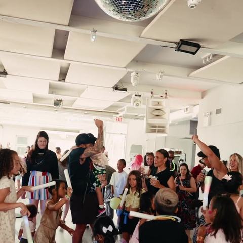 Kids and parents dancing under a disco ball at the first Tiny Rave at Bogart House